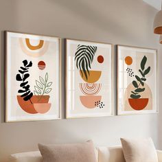 three framed art prints hanging on the wall above a couch