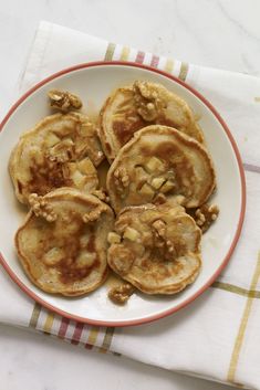 some pancakes are on a plate with walnuts