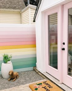 a pink door with a welcome mat in front of it