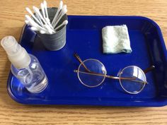 a blue tray with glasses, toothbrushes and napkins on it