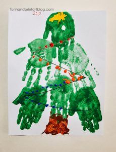 a child's handprint christmas tree made with green hands