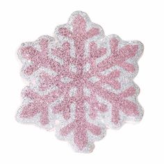 a pink and white snowflake with glitter on it's side, against a white background