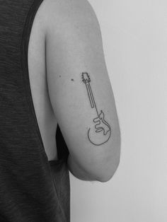 a person with a guitar tattoo on their arm