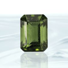 SpecificationsItem Code: MF097Metric Dimensions: 11 x 8 x 7 mmImperial Dimensions: ½” x ¼” x ¼” mmWeight: 4 Carats (0.8 grams) Unique QualitiesThis one of a kind Emerald Cut Genuine Moldavite Facet is a collector's dream. It features a crisp cut to emphasize its beautiful color and sparkle, making it an extraordinary addition to any jewelry collection. Perfectly faceted for maximum brilliance, it will bring you a subtle yet luxurious radiance that's sure to make a statement. Moldavite Stone, Gemstone Properties, Emerald Gem, Star Magic, Blue Kyanite, Dream It, Amethyst Crystal, Emerald Cut, Sterling Silver Pendants