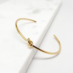 Tie the Knot Bracelet, Dainty Gold Bracelet, Love Knot Bracelet, Gold Cuff Bracelet, Minimalist Jewelry, Gold Bracelet ♥ Material: Hypoallergenic and Non Tarnishing Stainless Steel, High Quality and Long Lasting Color ♥ Color: Gold, Silver, Rose Gold ♥ Width: 2.5 inches (63 mm) / Adjustable Cuff ♥ Thickness: 2.0 mm - for medium 2.9 mm thickness: https://www.etsy.com/listing/849684570 - for thickest 3.8 mm thickness: https://www.etsy.com/listing/843125959 ♥ Gift Box Each item is shipped with a brown gift box (eco-friendly recycled) as pictured. ♥ More at PotissiDesign.etsy.com - Processing Time: 1-3 business days Bracelet Tie, Love Knot Bracelet, Bridesmaid Bracelet Gift, Celtic Bracelet, Knot Bangle, Dainty Gold Bracelet, Wedding Bridesmaid Jewelry, Bracelet Love, Bracelet Knots