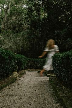 a blurry photo of a woman walking down a path