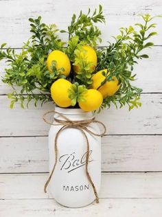 a mason jar filled with lemons and greenery