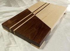 a wooden cutting board sitting on top of a white cloth covered tablecloth with wood strips cut in half