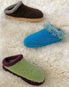 three pairs of slippers laying on top of a white rug next to each other