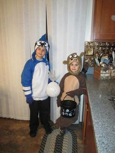 two children dressed up in costumes standing next to each other on a kitchen counter top