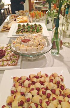 a table filled with lots of food on top of white plates and serving trays