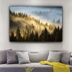 a painting hanging on the wall above a couch in a room with pillows and blankets