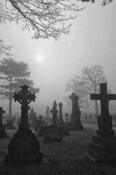 an old cemetery with crosses in the fog