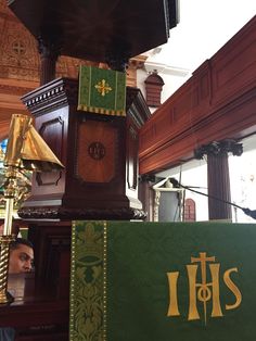 a large wooden clock sitting on top of a table next to a green sign that says it's 11