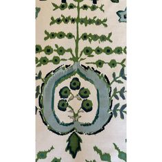 an intricately designed rug with green and blue flowers on it's side, in front of a white background