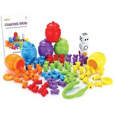 an assortment of colorful plastic toys including dices and gummy bears, with a book in the background