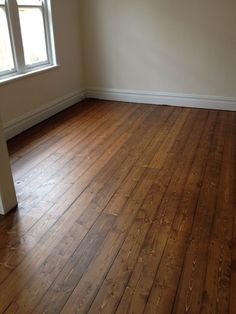 an empty room with hard wood floors and white walls