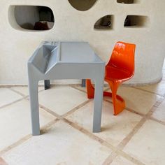 an orange chair sitting next to a gray table