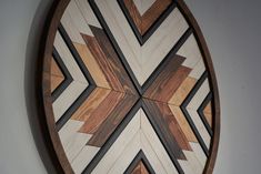 a wooden wall hanging on the side of a white wall with black and brown designs