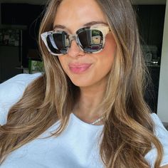 a woman with sunglasses on taking a selfie