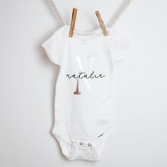 Kick off the baby shower or new born with this adorable custom onesie! Perfect for a baby name's announcement, group event or instagram shoot! This onesie reads the baby's name in a black script font with an uppercase single letter of the first name in rose gold or grey. Black script font with a grey or rose gold initial Handmade Turn inside out with cold wash // Dry on Low No Bleach // Softener ****CUSTOM ORDER**** How it works: When you check out please put your specifications in the NOTES. Th Personalized Fitted Onesie For Gender Reveal, White Custom Name Fitted Onesie, White Fitted Onesie With Custom Name, Baby Name Announcement, Rose Gold Initial, Custom Onesies, Single Letter, Gold Initial, First Name