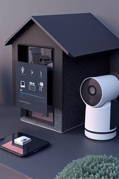 a smart home security camera sitting next to a phone and tablet computer on a desk