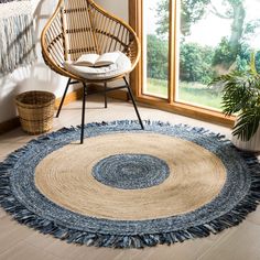 a room with a chair and rug on the floor next to a large open window