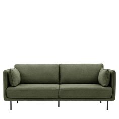 a green couch sitting on top of a white wall next to a black metal frame