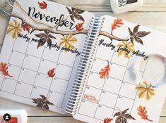 an open planner with autumn leaves on it