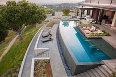 an aerial view of a house with a pool and lounge chairs in the foreground