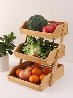 three wooden crates filled with different types of fruits and vegetables on top of a kitchen counter