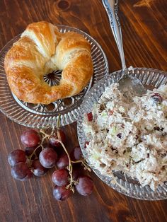 there is a bowl of rice and a croissant with grapes on the side