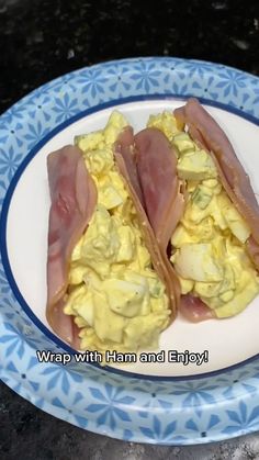 two pieces of bacon and scrambled eggs on a blue and white plate with the words wrap with ham and enjoy