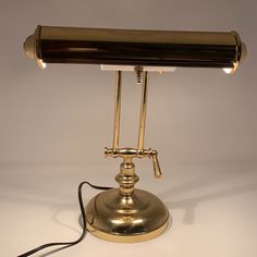 an antique brass desk lamp on a white background