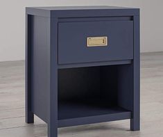 an image of a night stand on the floor with one drawer open and gold handles