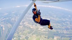 a man is skydiving in the air with his hands up and feet apart