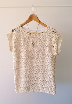 a white top hanging on a wooden hanger