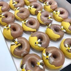 a box filled with donuts covered in chocolate frosting and decorated like bee's