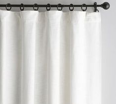 a white curtain hanging on a metal rod