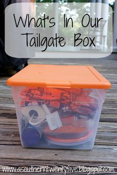 a plastic container filled with assorted items on top of a wooden table