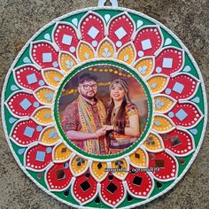 a colorful photo hanging on the side of a wall next to a tile floor with an image of a man and woman