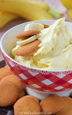 a bowl filled with ice cream and cookies on top of a table next to bananas