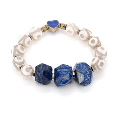 The Eye of Love Chunky Lapis Lazuli Beaded Bracelet is a stunning piece of handmade jewelry that is sure to capture attention. It features a center of Lapis Lazuli stone beads, which are known for their deep blue color and are believed to promote inner peace, self-awareness, and spiritual enlightenment. The combination of lapis lazuli, White agate, and the Gold plated blue enamel heart bead creates a striking visual contrast, making the Eye of Love Chunky Lapis Lazuli Bracelet a unique and eye-catching accessory Details 10mm White agate stone beads 16. 5mm Lapis Lazuli stone beads Gold color hematite stone spacers 18K Gold plated blue enamel heart bead Bracelet size 6. 5" Avoid contact with chemicals, makeup, parfume. Do not use dips or abrasive cleaners on bracelet. To clean and brighten Blue Heart Beads Bracelet Jewelry, Blue Heart Beads Bracelet, Bohemian Blue Heart Beads, Artisan Blue Gemstone Beads Bracelets, Artisan Blue Bracelets With Gemstone Beads, Blue Spiritual Bracelets With Large Beads, Lapis Lazuli Bracelet, Lapis Lazuli Beads, Hematite Stone