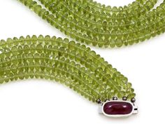 An 18K white gold multi-strand peridot bead necklace set with an elongated cabochon ruby and pavé diamond clasp. Metal: 18K White Gold Gemstone: Peridot: 985 carats Gemstone: Ruby: 10.58 carats Gemstone: Diamonds: 0.26 carats Design Era: Contemporary Cabochon Ruby, Ruby Necklace, Knot Necklace, Multi Strand, Bead Necklace, Pave Diamonds, Jewelry Branding, Gemstone Necklace, Necklace Set