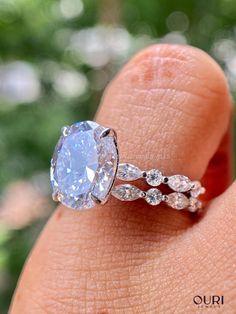 a woman's hand holding an engagement ring with a large blue diamond in it