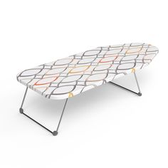 an ironing board is sitting on top of a folding table, with circles painted on it