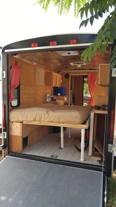 the inside of a camper with its bed pulled up to it's side