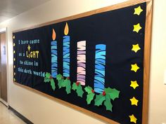 a bulletin board with christmas decorations on it in an office hallway, decorated for the holiday season