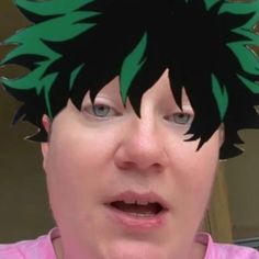 a close up of a person with green hair wearing a pink shirt and black headband