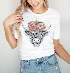 a woman wearing a white t - shirt with flowers on her head is posing for the camera